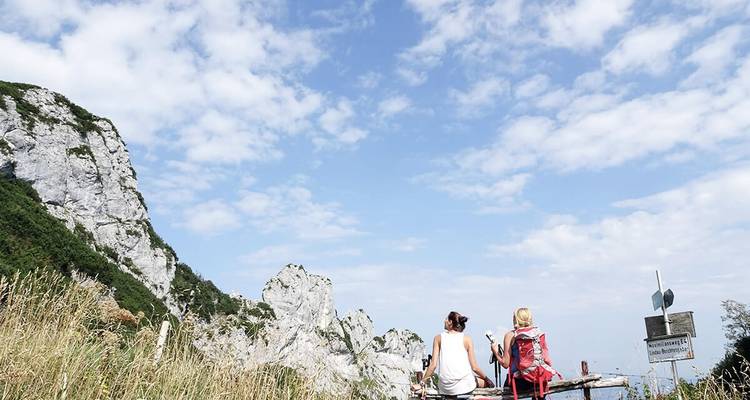Deux personnes assises sur un banc avec vue sur la montagne.