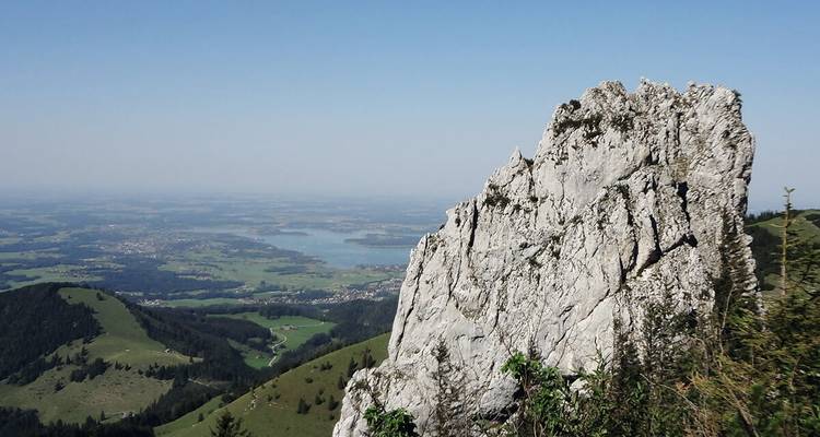 Une grande formation rocheuse surplombant un lac lointain.
