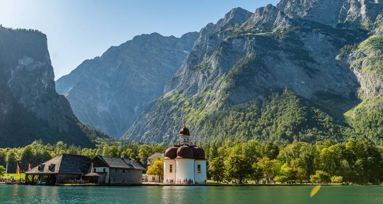 Une église historique sur un lac de montagne calme avec un arrière-plan dramatique.