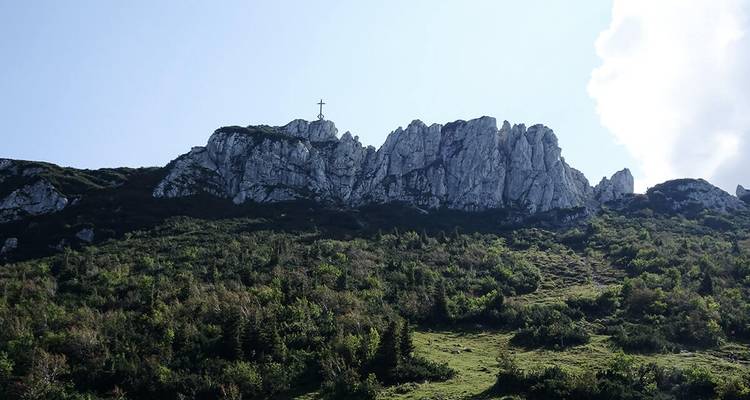 Paysage de montagne avec une croix au sommet de la colline.