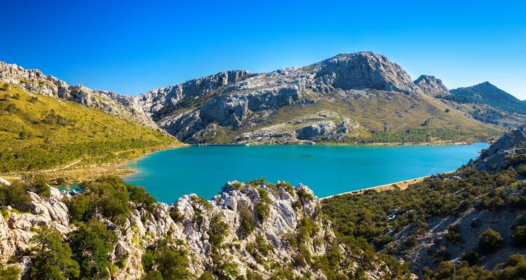 Mountain lake with rocky shores and clear blue water.