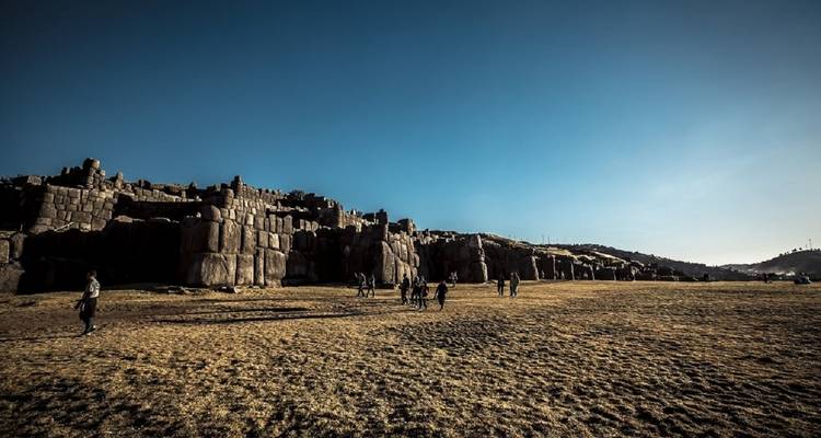 Weitläufige antike Ruinen mit Menschen, die das Gebiet erkunden.