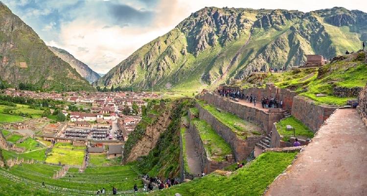 Historische Inca-locatie met terrassen, bergen en mensen die aan het verkennen zijn.