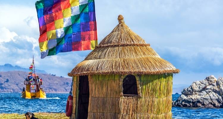 Rieten hut aan het Titicacameer met een levendige veelkleurige vlag op de achtergrond.