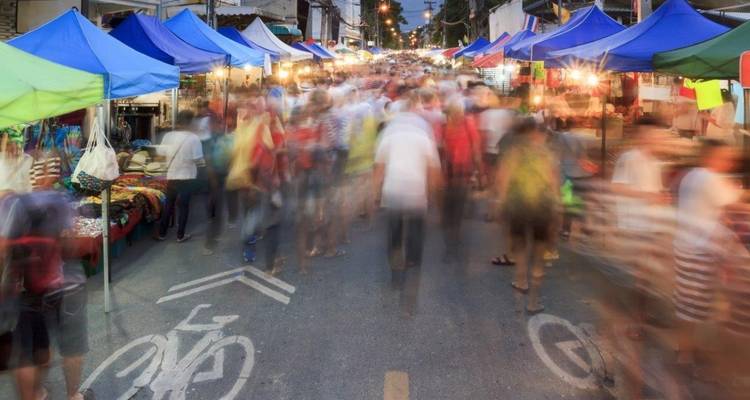 Vista borrosa de un mercado callejero bullicioso por la noche.