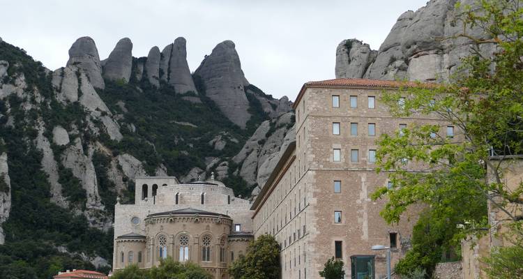 Monastère entouré d'un paysage montagneux rocheux.