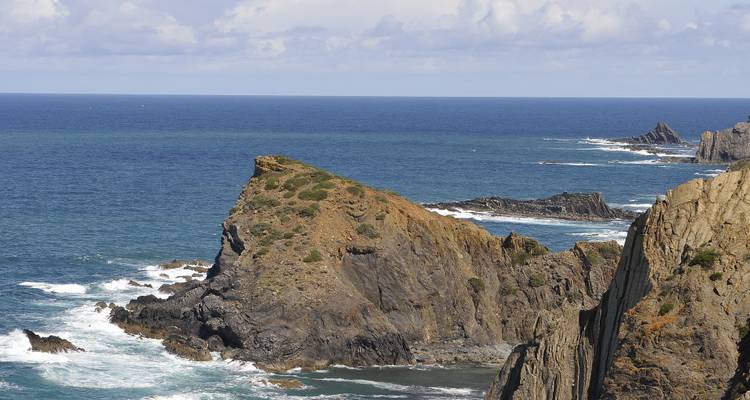 Dramatische kustklif met beukende golven en uitgestrekte oceaanzichten.