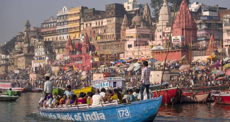 Escena fluvial concurrida con barcos y edificios de la ciudad, observada desde la orilla del río.