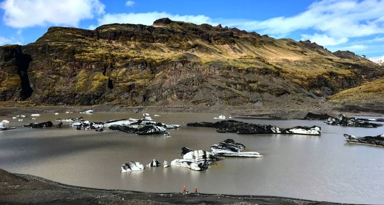 Icebergs floating on a glacial lake surrounded by mountains.