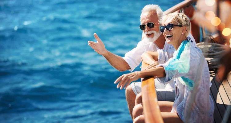 Ein älteres Paar auf einem Boot, das den Blick auf den Ozean genießt.