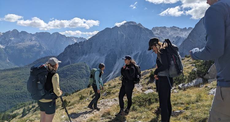 Groupe de randonneurs sur un sentier de montagne avec des vues panoramiques.