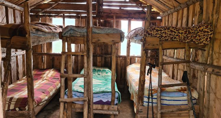 Intérieur d'un dortoir rustique avec des lits en bois.