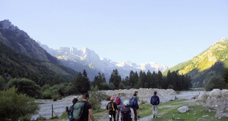 Groupe de randonneurs sur un sentier de montagne avec des vues panoramiques.