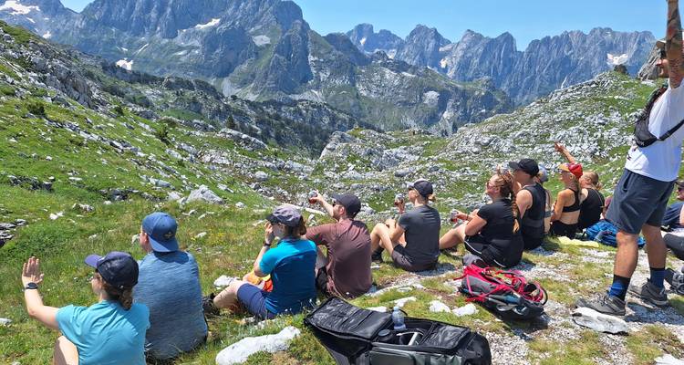 Gruppe von Menschen, die an einem Berghang mit malerischer Aussicht ruhen.