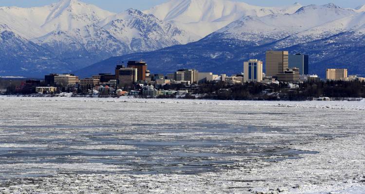 Horizon urbain avec des montagnes en arrière-plan et de l'eau gelée.