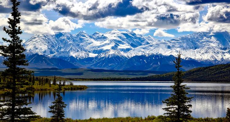 Vue à couper le souffle d'un lac avec des montagnes enneigées.
