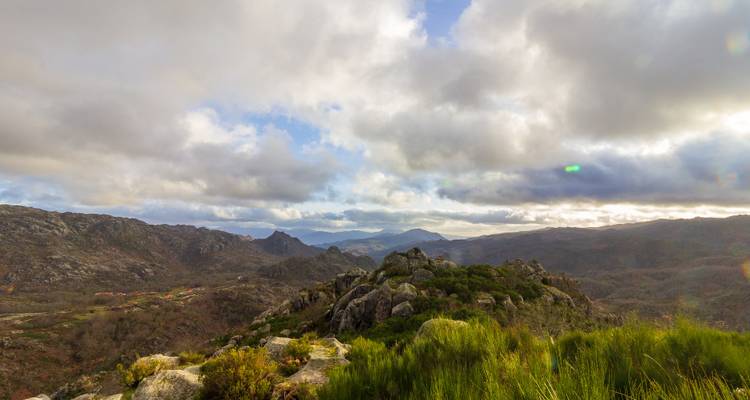 Wide mountain vista with rocky outcrop and moody cloud-filled sky over northern Portugal’s wilderness.
