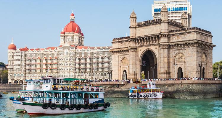 De Gateway of India met boten op een kalme zee in Mumbai.