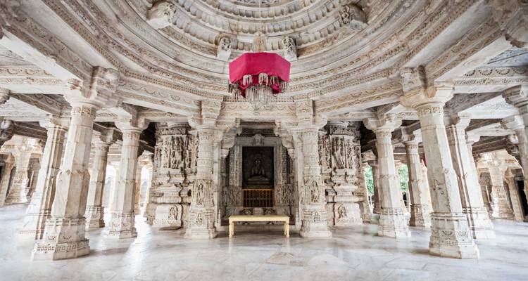 Ingewikkeld interieur van de Ranakpur Jain-tempel met pilaren en een centraal standbeeld.