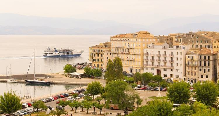 Coastal cityscape with a dock and a ferry.