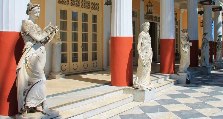 Statues of figures in traditional Greek attire.