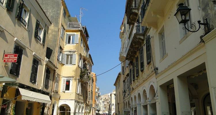 Narrow street with old buildings and balconies.