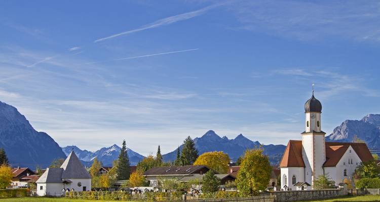 Charming village with a church and mountain backdrop.