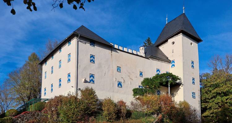 Historic building on a hill surrounded by autumn foliage.