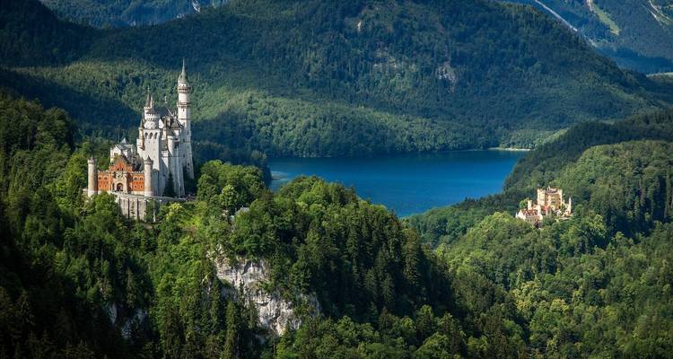 Château de Neuschwanstein entouré de forêts denses et d'un lac.