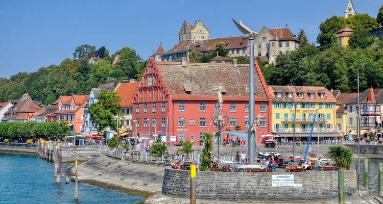 Ville historique colorée s'élevant sur une colline au-dessus du lac bleu avec un château au sommet.