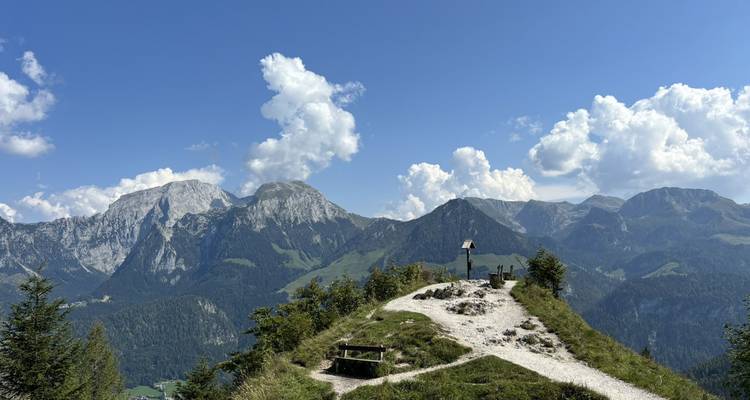 Paysage de montagne avec un petit sentier menant à un banc.