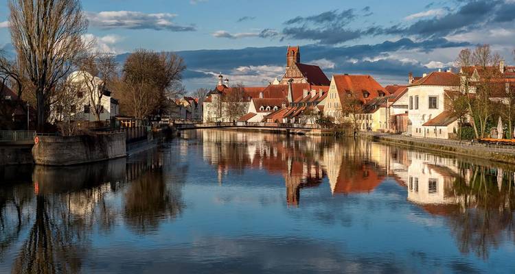 Malerisches Städtchen mit Gebäuden, die sich in einem Fluss spiegeln.