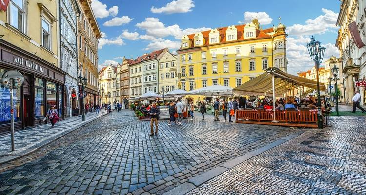 Outdoor cafe on a cobblestone street surrounded by historic buildings.