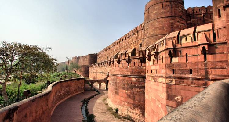 Massieve rood zandstenen muren en bastions van Agra Fort onder een helder lucht.
