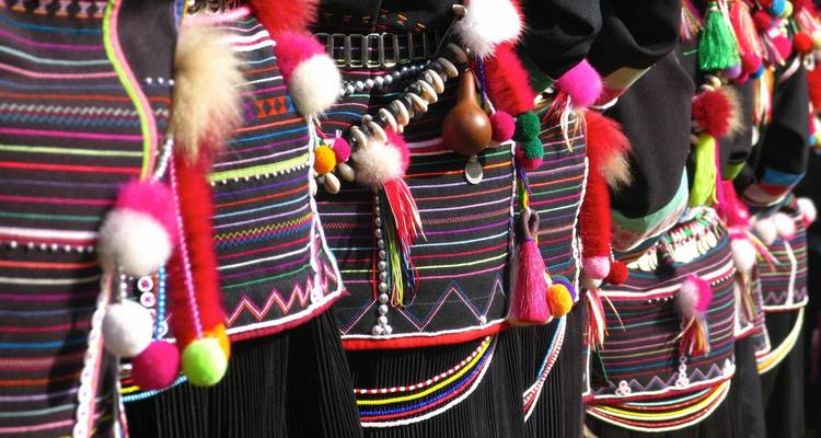 Close-up van kleurrijke traditionele kledingdetails met kralen en pompons.