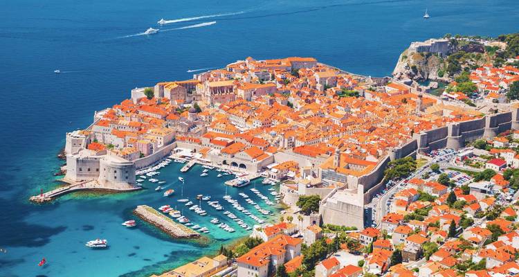 Panoramisch luchtfoto van Dubrovnik's versterkte Oude Stad en jachthaven omgeven door het levendige blauwe Adriatische zeewater