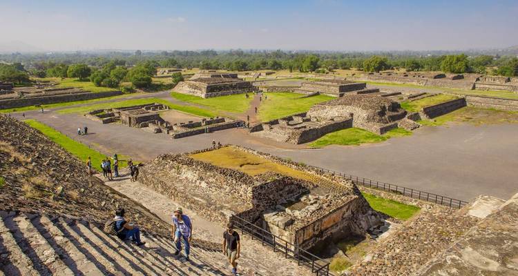 Vue panoramique sur le paysage urbain antique de Teotihuacán avec des touristes explorant les ruines.