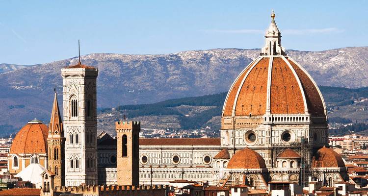 La icónica cúpula de tejas rojas y el campanario de la Catedral de Florencia con las colinas toscanas de fondo