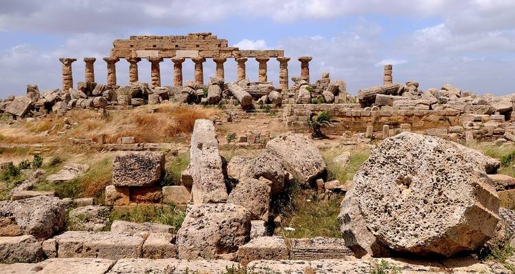 Antike Ruinen mit Säulen und verstreuten Steinstrukturen.