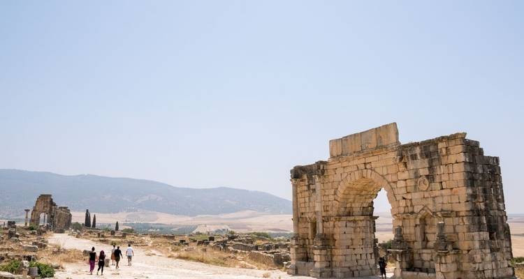 Grupo explorando ruinas antiguas bajo un cielo despejado.