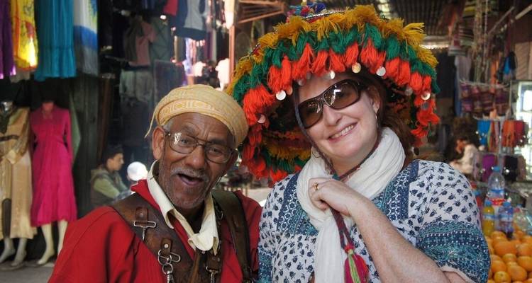 Dos personas en un mercado animado vistiendo atuendo tradicional.