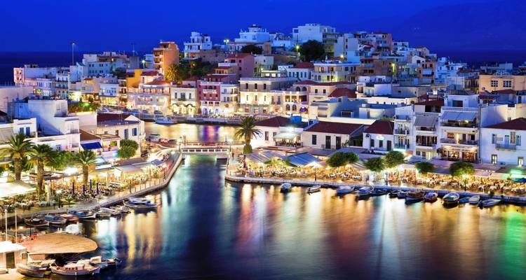 Ville côtière avec des bâtiments illuminés la nuit.