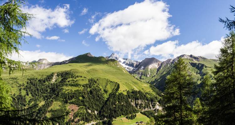 Paysage de montagne à Lofer avec des collines vertes et des sommets enneigés.