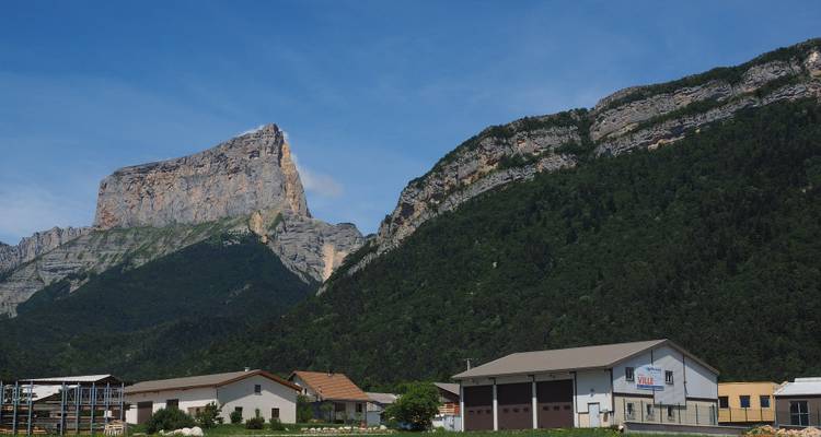 Majestueuse chaîne de montagnes avec des bâtiments au premier plan.