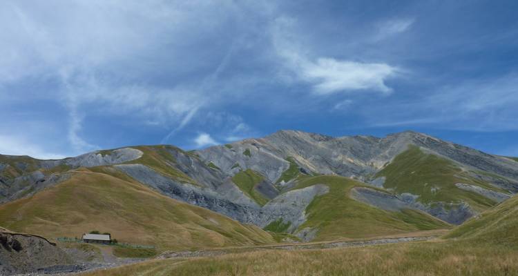 Paysages montagneux étendus aux pentes herbeuses.