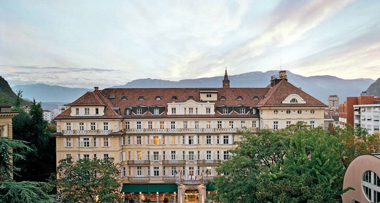 Historisches Gebäude mit Bergen im Hintergrund bei Sonnenuntergang