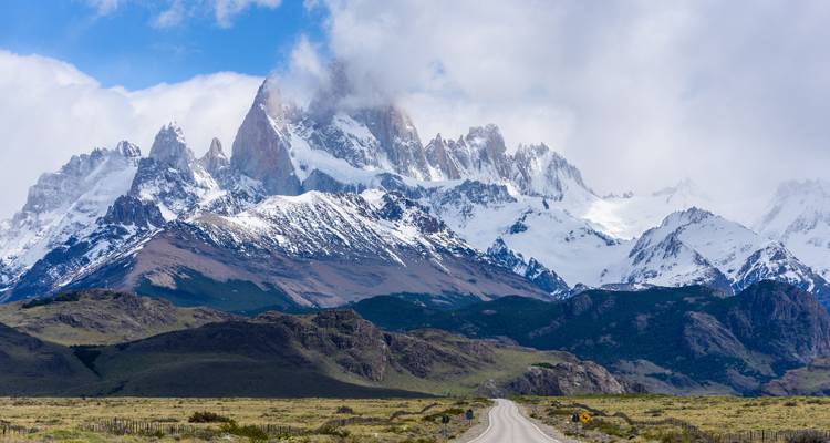 Lange, rechte weg die naar de met sneeuw bedekte Mount Fitz Roy leidt, die majesteitelijk boven de Patagonische vlakte uittorent.