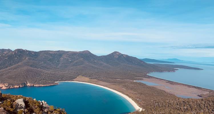 Panoramisch uitzicht op een halvemaanvormig strand in een nationaal park.