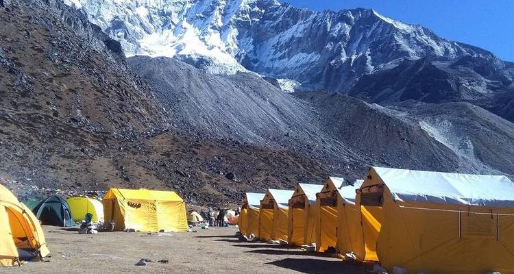 Zelte am Fuß eines schneebedeckten Berges.