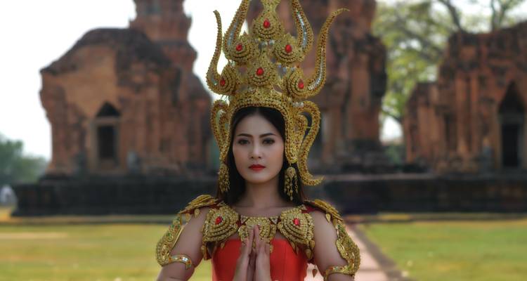 Woman in traditional ornate costume in front of temple